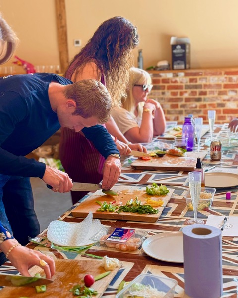 Guests chopping fresh vegetables during a hands-on cooking session